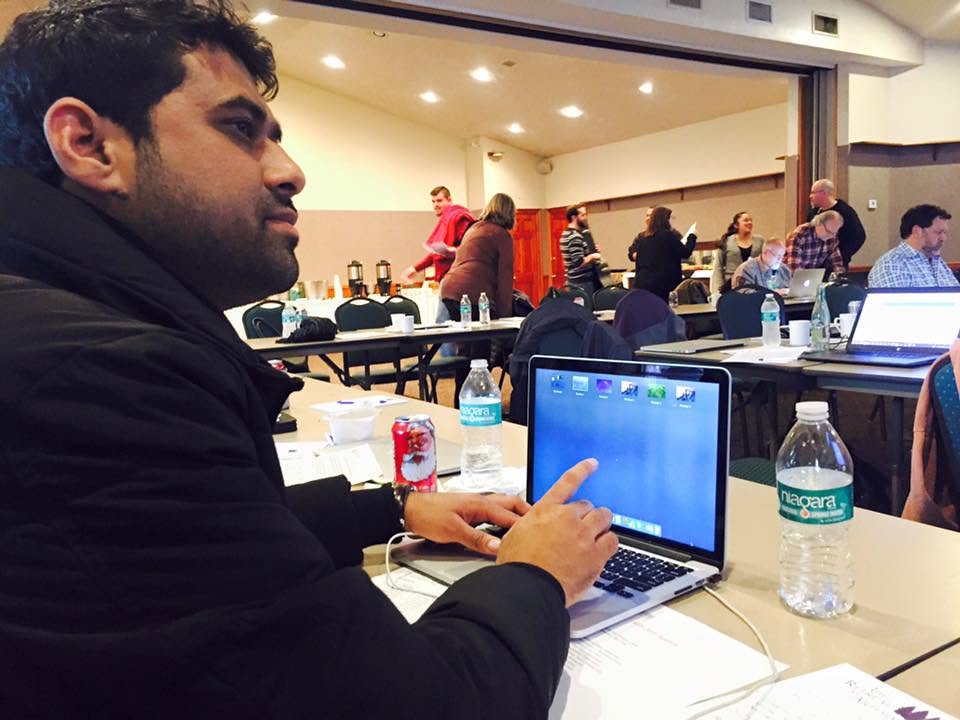 Wasim Sheikh at a technology conference working on laptop